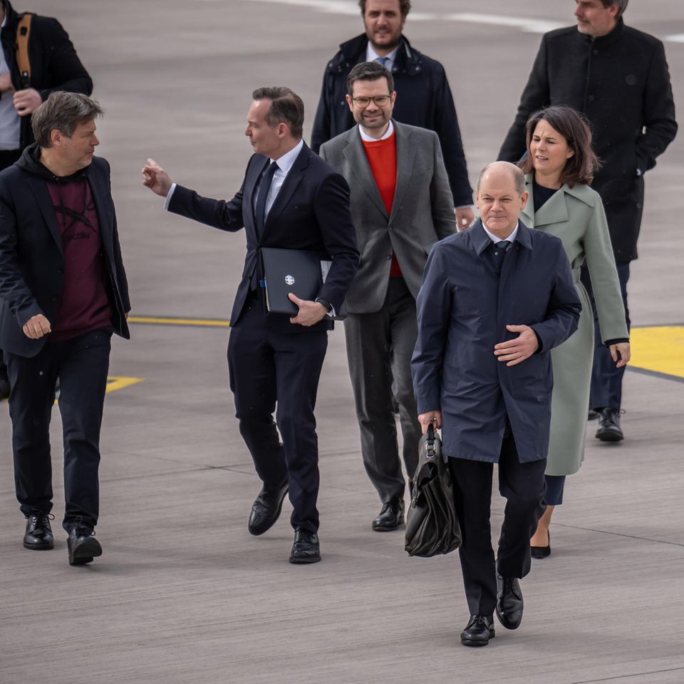 Bundeskanzler Olaf Scholz (SPD, vorne), gefolgt von mehreren Kabinettsmitgliedern, am Flughafen Berlin-Brandenburg