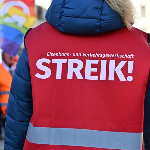"Strike!" stands on the warning vest of a participant on the warning strike in front of the Erfurt main station