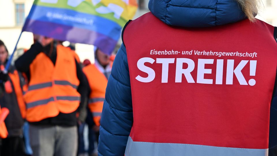 "Streik!" steht auf der Warnweste einer Teilnehmerin am Warnstreik vor dem Erfurter Hauptbahnhof