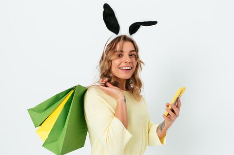 Eine Frau trägt Einkaufstüten und Hasenohren