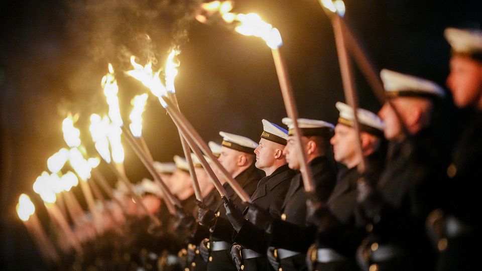 Bundeswehr soldiers of the guard battalion line up for the farewell with torches