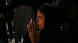  Eine Frau betet während einer Mahnwache für die Opfer eines Brande