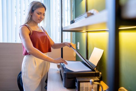 Eine Frau steht am Drucker