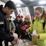 Ein Rettungshelfer versorgt Kinder und Jugendliche im Heizzelt "Point of Invincibility" ("Punkt der Unbesiegbarkeit") mit warmen Getränken. Die Menschen in Butscha haben schwere Schicksale zu ertragen und zu verarbeiten. Der Siegeswille scheint trotzdem – oder gerade deswegen – ungebrochen.