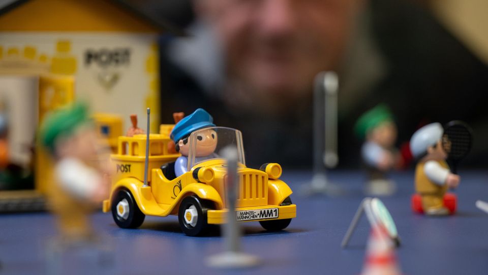 Ein Mann schaut sich ein Mainzelmännchen im Postauto an