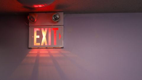 Ein leuchtendes Exit-Schild hängt an einer Decke.