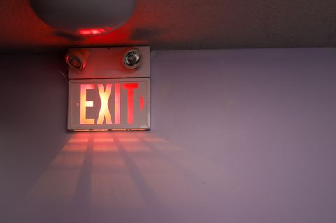 Ein leuchtendes Exit-Schild hängt an einer Decke.
