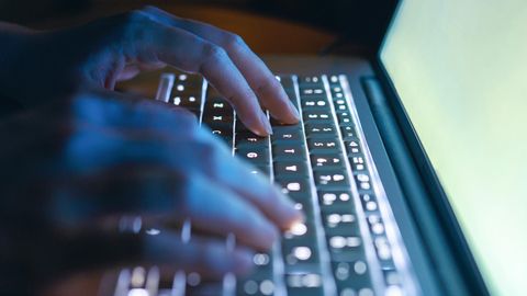 Hände tippen auf einer Laptop-Tastatur