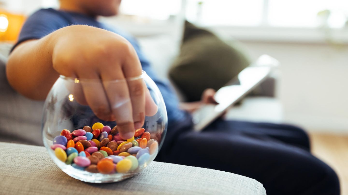 Übergewichtiges Kind mit Süßkram und Tablet