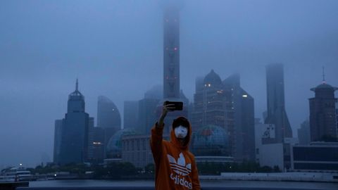 Ein Anwohner Sanghai macht bei Tagesanbruch ein Selfie