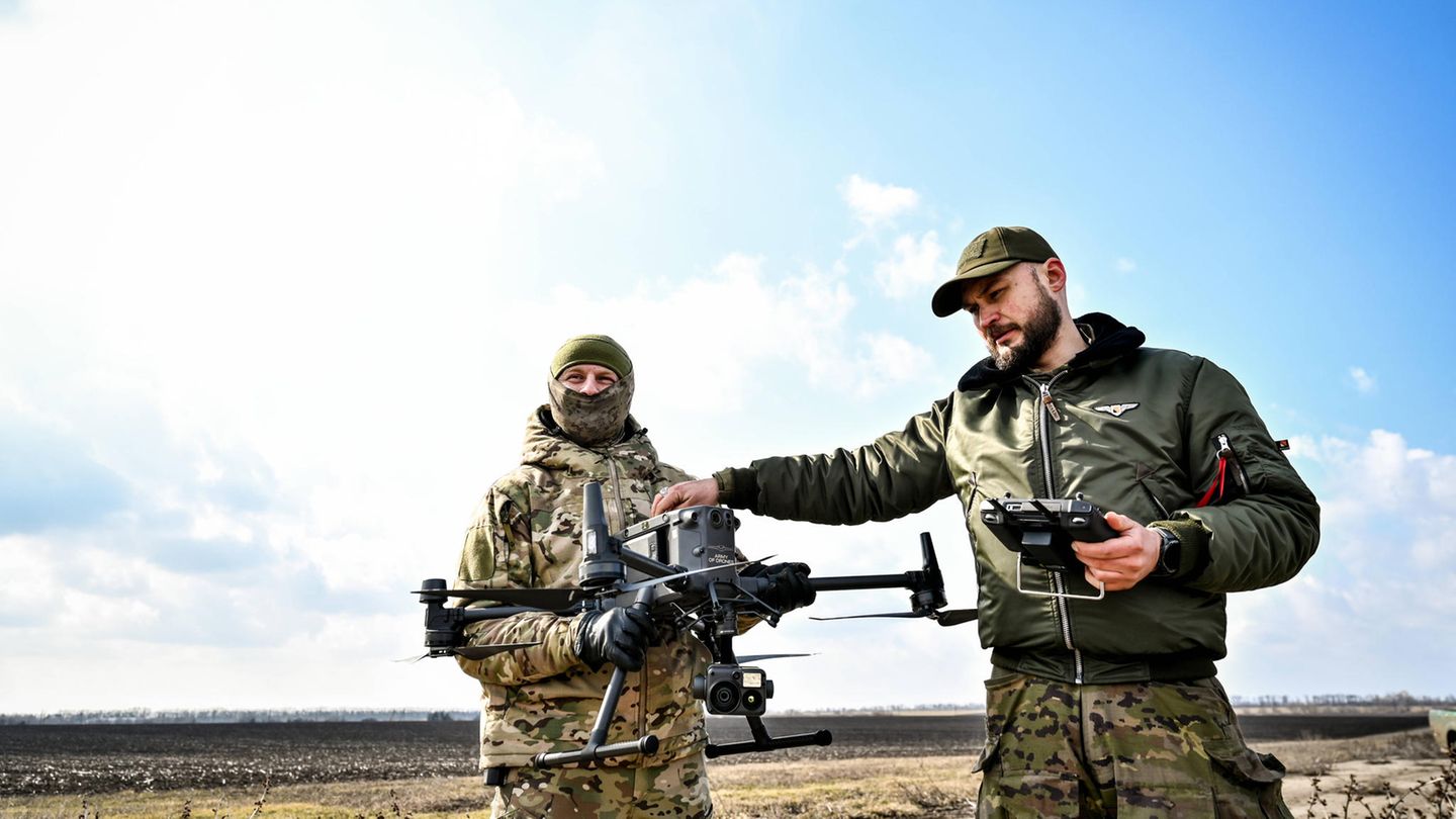 Zwei Soldaten in der Ukraine halten eine Drohne in den Händen