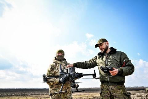Zwei Soldaten in der Ukraine halten eine Drohne in den Händen