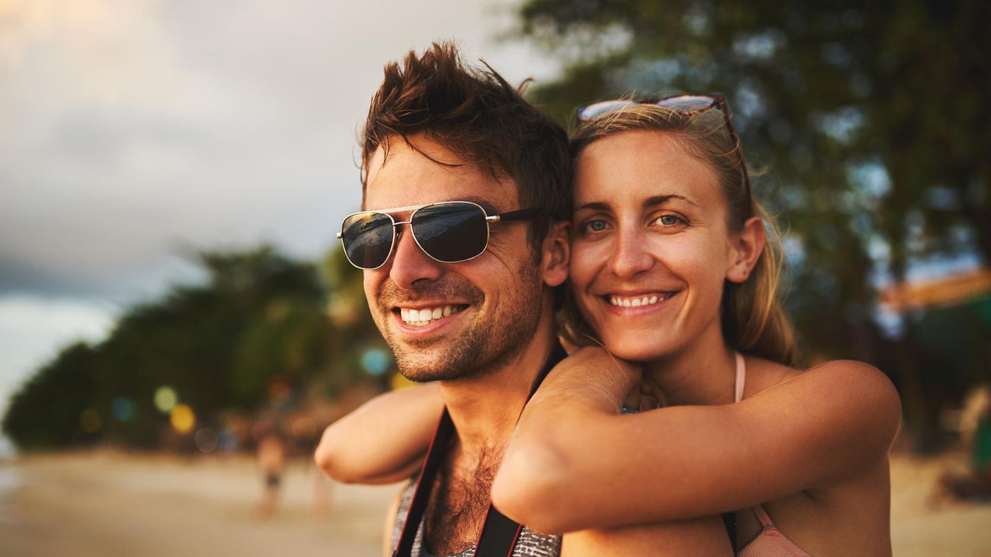 Sonnenbrillen für Männer: Junges Pärchen am Strand, er mit Sonnenbrille
