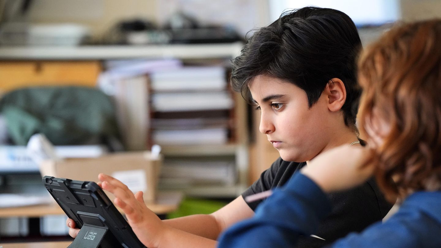 Schüler der fünften Klasse vor einem Tablet