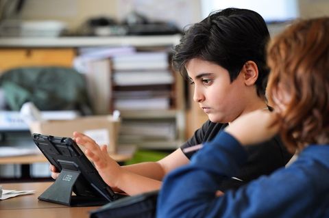 Schüler der fünften Klasse vor einem Tablet