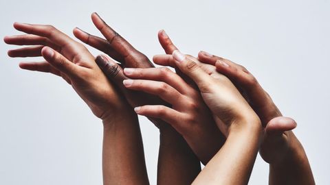 Hände verschiedener Hautfarben greifen ineinander. Besonders in der Dermatologie spielt Inklusion eine große Rolle.