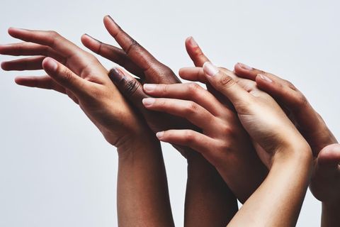 Hände verschiedener Hautfarben greifen ineinander. Besonders in der Dermatologie spielt Inklusion eine große Rolle.