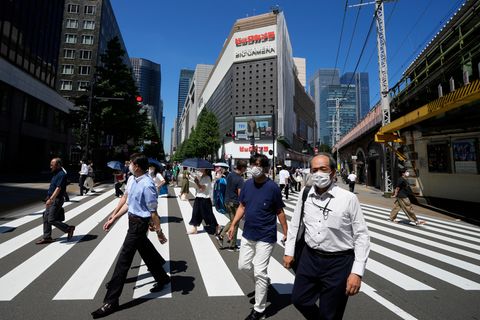 Menschen die über eine Kreuzung in Tokio, Japan, gehen
