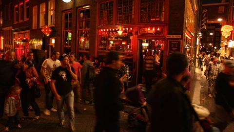 Touristen in Amsterdam gehen durch das Rotlichtviertel