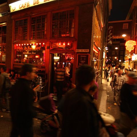 Touristen in Amsterdam gehen durch das Rotlichtviertel