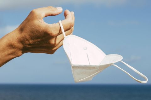 Eine Hand hält eine Maske