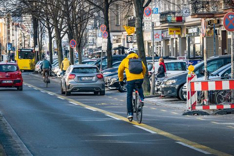 Ein Auto parkt auf einer Straße in Berlin auf dem Radweg, Radfahrer müssen ausweichen