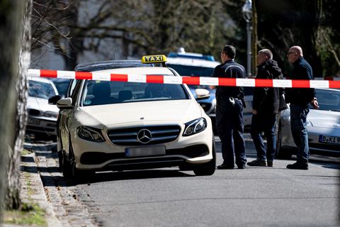 Polizisten untersuchen das Taxi, in dem ein tödlicher Angriff auf den Taxifahrer in Berlin-Grunewald verübt wurde