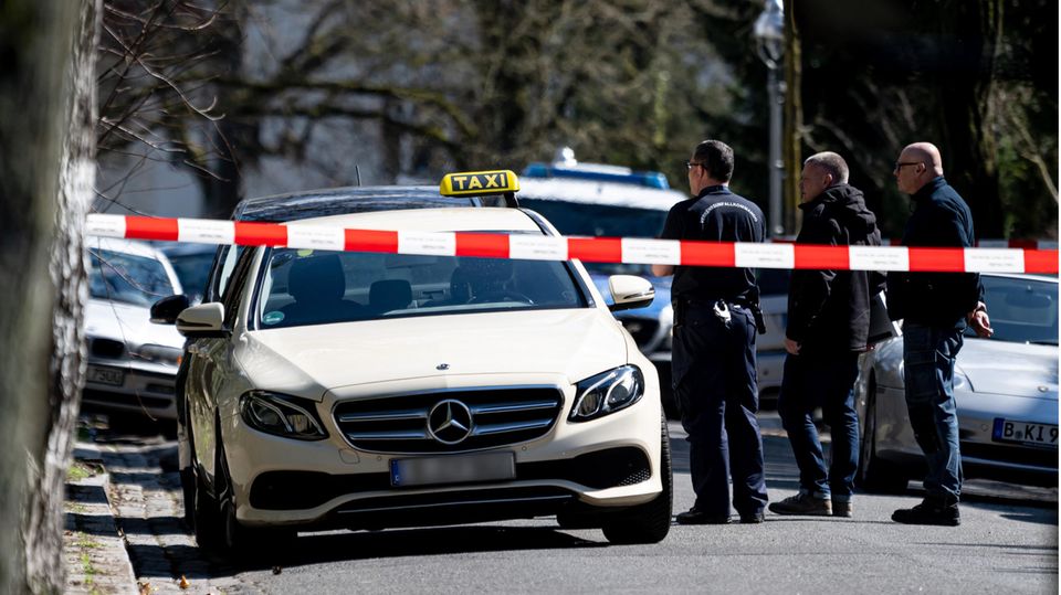 Polizisten untersuchen das Taxi, in dem ein tödlicher Angriff auf den Taxifahrer in Berlin-Grunewald verübt wurde
