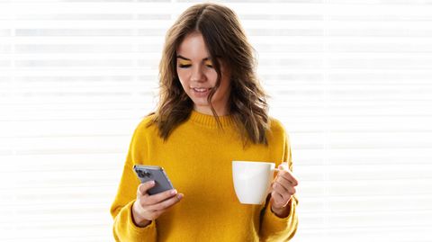 Frau mit Apple iPhone und Kaffee