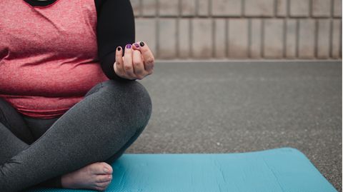 Übergewichtige Frau auf einer Yogamatte