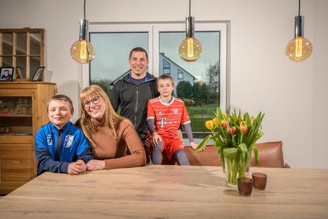 Nadine und Benedikt Jakobs mit dem achtjährigen Eliah (l.) und dem neunjährigen David, der jüngste Sohn lag krank auf dem Sofa. Das neue Heim der Familie ist tief im Hunsrück, rund 100 Kilometer von Köln entfernt