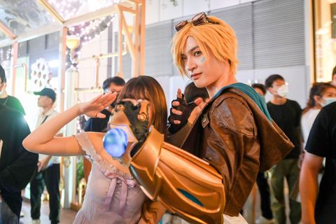 Ein Cosplayer posiert neben einer Frau für die Kamera auf einer Convention in Shenzhen, China