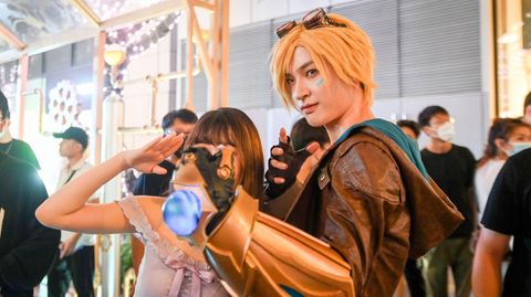 Ein Cosplayer posiert neben einer Frau für die Kamera auf einer Convention in Shenzhen, China