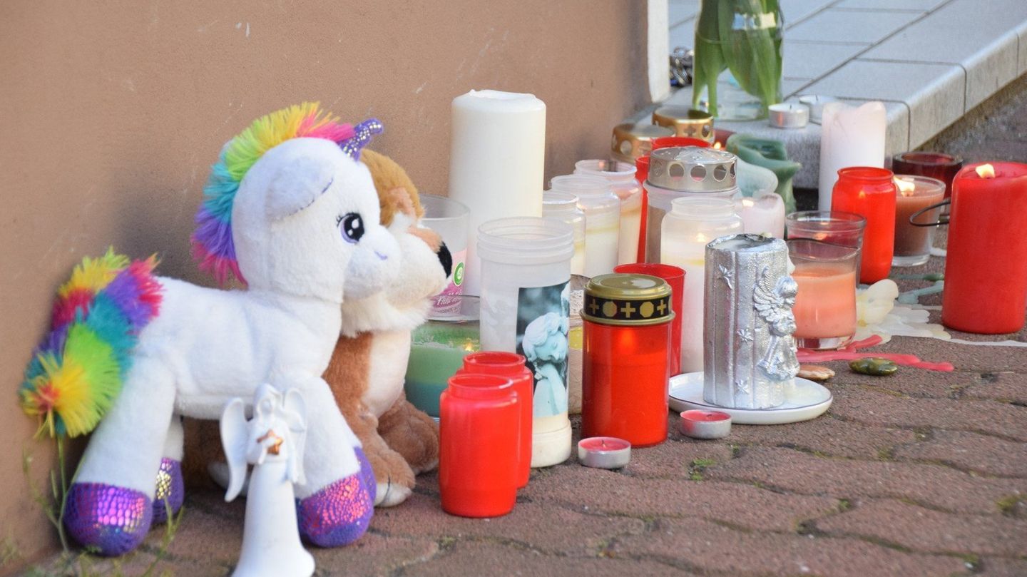 Plüschtiere und Kerzen stehen am Hauseingang zur Wohnung in Hockenheim, in der zwei Brüder tot gefunden worden