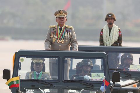 Der Chef der Militärjunta in Myanmar steht im Auto und fährt auf einer Militärparade