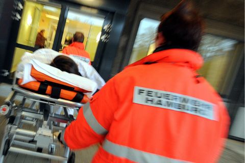 Sanitäter schieben eine verletzte Person auf der Liege in die Notaufnahme