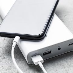 Ein Smartphone lädt auf einer Powerbank.