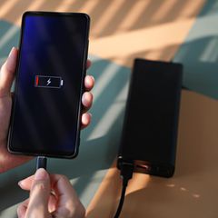 Ein Smartphone lädt auf einer Powerbank.