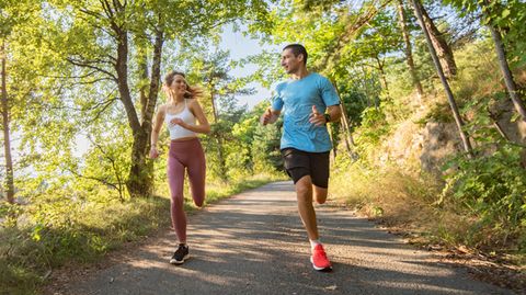 Sport hilft der Psyche: Ein Mann und eine Frau joggen im Park