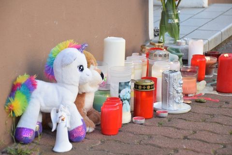 Plüschtiere und Kerzen stehen am Hauseingang vor der Wohnung, in der am Ostersonntag zwei tote Kinder gefunden wurden