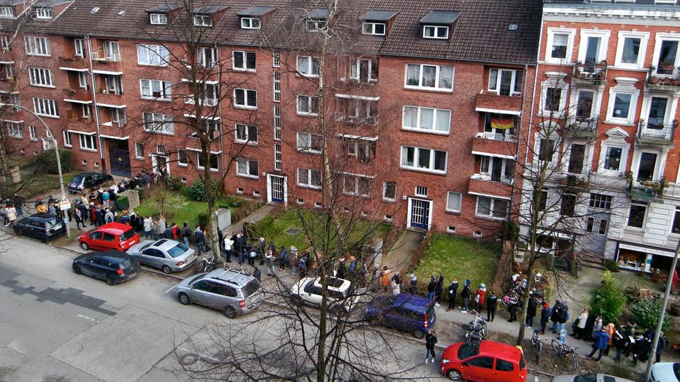 Eine Schlange von Menschen vor einem Wohnungsblock
