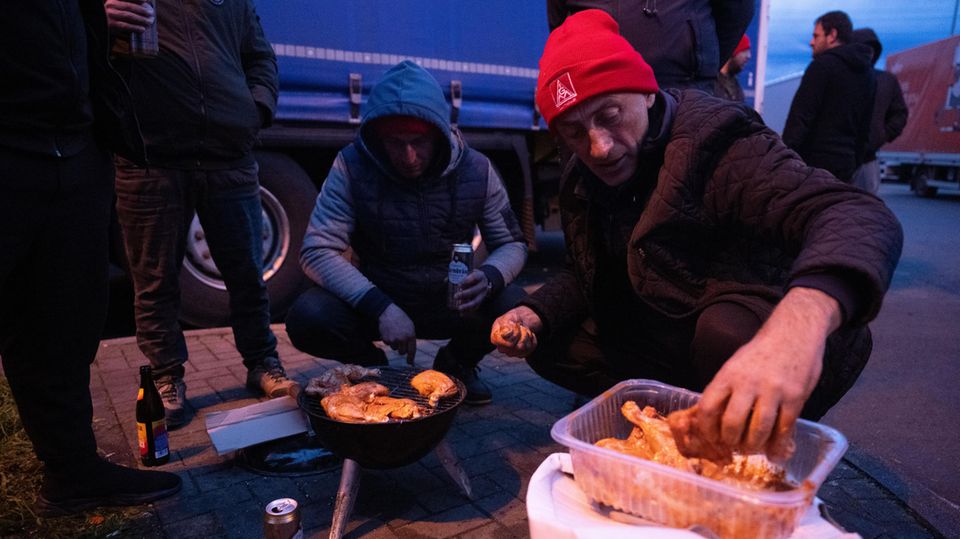 Beim Streik grillen die Männer vor ihren LKW