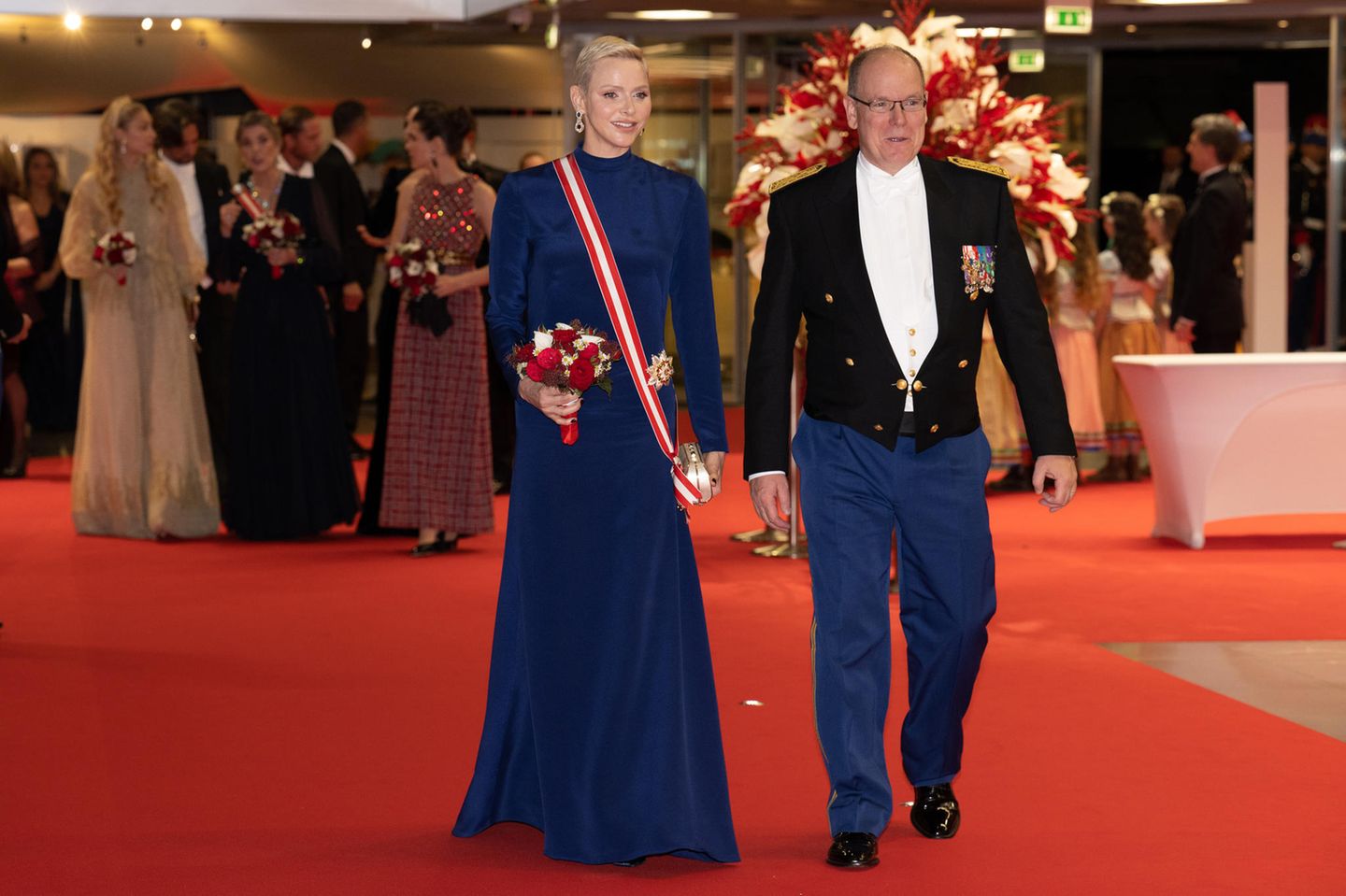 Monaco: Endlich konnte man die Fürstin beim Nationalfeiertag im November 2022 wieder sehen! Nach ihrer krankheitsbedingten Pause im Vorjahr strahlte Charlène bei ihrem Comeback umso mehr. Für den Abend hatte sie sich für ein maßangefertigtes Kleid in Dunkelbau von Terrence Bray entschieden – passend zur Hose ihres Gatten. Um ihren Körper schlang sich eine Schärpe in den Farben des Zwergstaats, an ihrer Hüfte glänzte der Hausorden der Grimaldis. Endlich konnte man die Fürstin beim Nationalfeiertag im November 2022 wieder sehen! Nach ihrer krankheitsbedingten Pause im Vorjahr strahlte Charlène bei ihrem Comeback umso mehr. Für den Abend hatte sie sich für ein maßangefertigtes Kleid in Dunkelbau von Terrence Bray entschieden – passend zur Hose ihres Gatten. Um ihren Körper schlang sich eine Schärpe in den Farben des Zwergstaats, an ihrer Hüfte glänzte der Hausorden der Grimaldis.