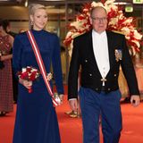 Endlich konnte man die Fürstin beim Nationalfeiertag im November 2022 wieder sehen! Nach ihrer krankheitsbedingten Pause im Vorjahr strahlte Charlène bei ihrem Comeback umso mehr. Für den Abend hatte sie sich für ein maßangefertigtes Kleid in Dunkelbau von Terrence Bray entschieden – passend zur Hose ihres Gatten. Um ihren Körper schlang sich eine Schärpe in den Farben des Zwergstaats, an ihrer Hüfte glänzte der Hausorden der Grimaldis.