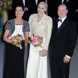 Rock'n'Roll beim Rosenball! Fürstin Charlène strahlte 2013 neben ihrer älteren Schwägerin, Prinzessin Caroline von Hannover, und Ehemann Albert in einer cremefarbenen Lederjacke. Darunter kommt das weiße Kleid von Ralph Lauren hervor. Unter der Jacke versteckt: Das eigens für die Monarchengattin angefertigte Kleid ist an den Schulterpartien mit den gleichen Kristallschnüren besetzt, wie sie Charlène um den Hals trug. Ein gewagter Look – vielleicht mit Bedacht, denn es war der letzte Rosenball der Fürstin. Ab 2014 überlässt sie das Charity-Event Caroline.