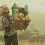Mann trägt auf dem Rücken Körbe mit Schwefelplatten