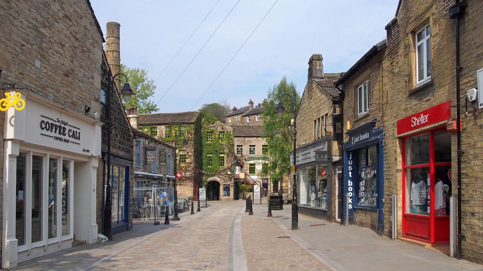 Eine Straße in Hebden Bridge, in der sich Café und kleine Geschäfte aneinanderreihen