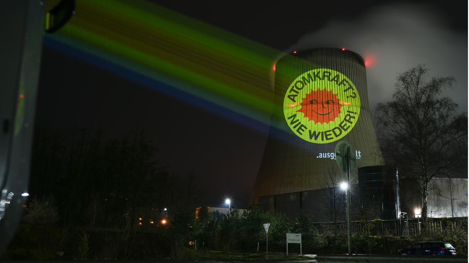 Aktivisten der Anti-Atom-Bewegung projizieren eine große Anti-Atom-Sonne auf den Kühlturm des Atomkraftwerkes Emsland