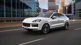 Der neue Porsche Cayenne fährt auf einer Straße durch städtische Umgebung