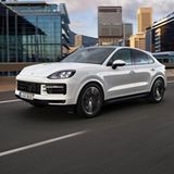 Der neue Porsche Cayenne fährt auf einer Straße durch städtische Umgebung